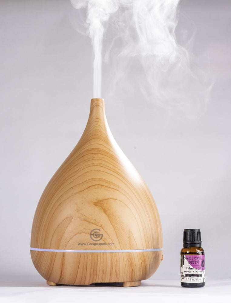 Wooden diffuser with steam and a bottle of essential oil on a white background