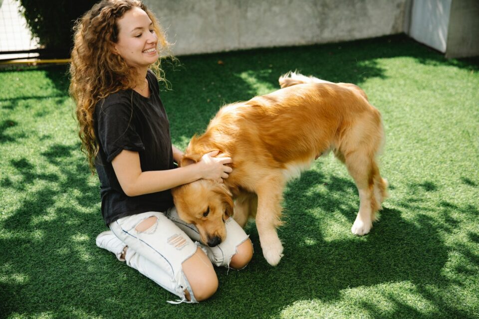 A young woman scratching her brown dogs neck