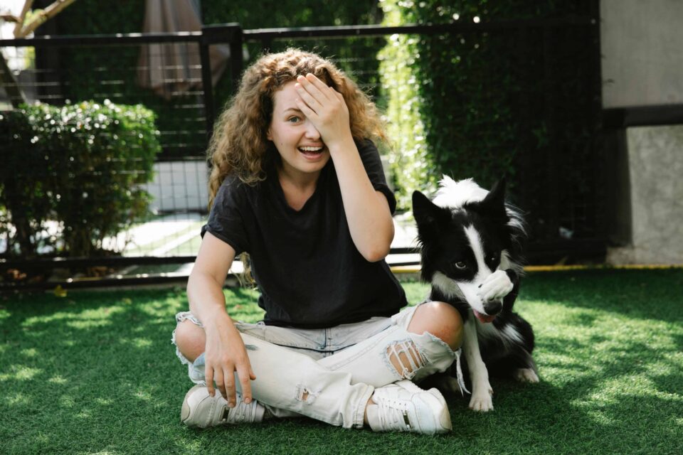 content woman taming border collie on lawn