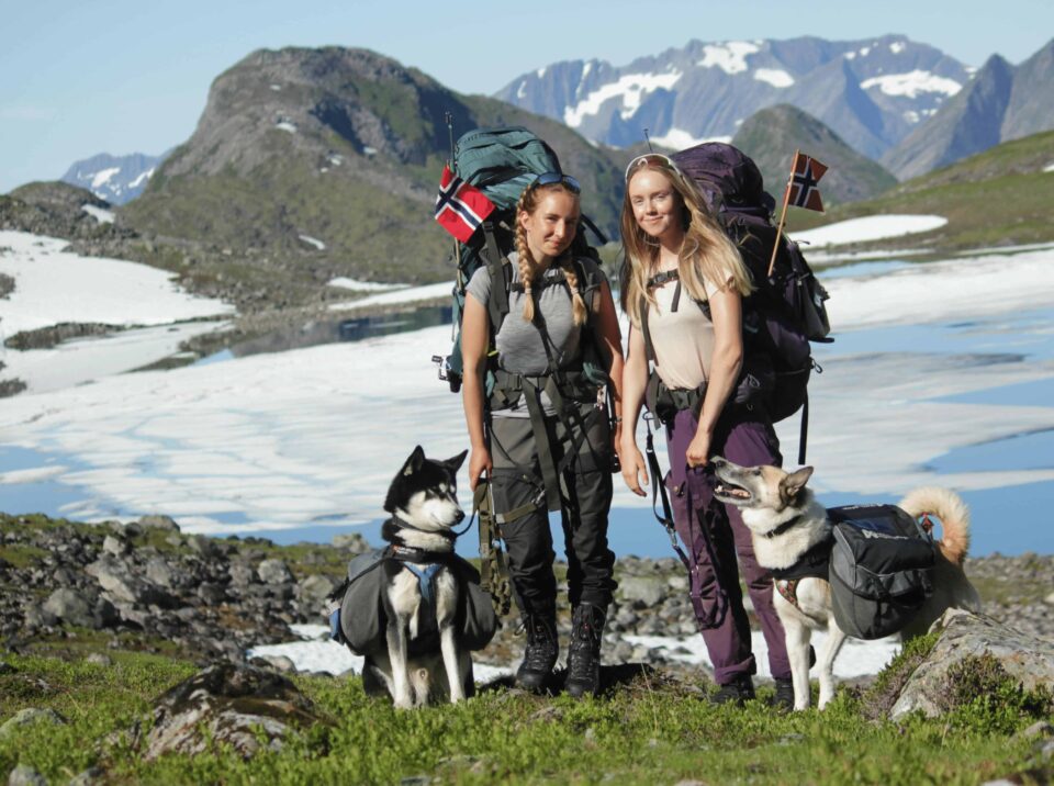 two women with dogs while backpacking in the mountains